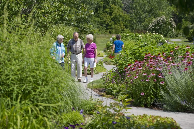 Seniors at Canterbury-on-the-lake walking outside in a garden.